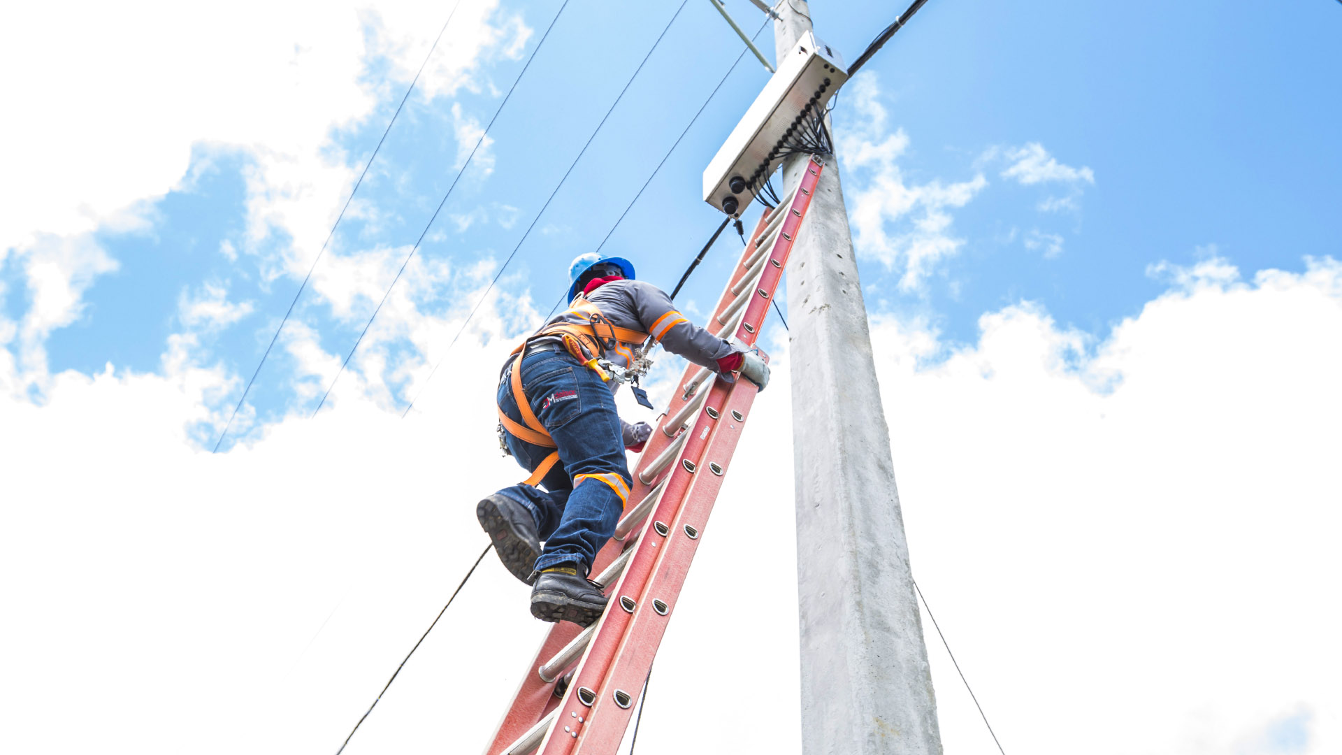 Técnico subiendo a poste eléctrico